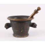 A bronze pestle and mortar, the mortar flanked by twin mask handles, height 12cm