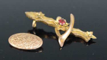 A 9ct gold and garnet set wishbone brooch, 41mm, together with 9ct gold cufflink (front only), gross