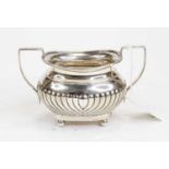 A George V silver twin handled sugar bowl, of half-fluted bombe form, on ball feet, 6.4oz