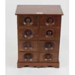 A walnut table-top chest, containing an arrangement of eight short drawers upon bracket feet, h.