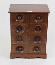 A walnut table-top chest, containing an arrangement of eight short drawers upon bracket feet, h.