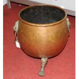 A 19th century brass and copper jardiniere, flanked by twin lion mask handles and standing upon