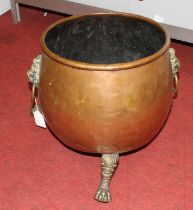 A 19th century brass and copper jardiniere, flanked by twin lion mask handles and standing upon