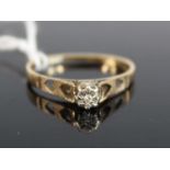 A modern 9ct gold diamond solitaire ring, the illusion set small brilliant weighing approx 0.04ct,