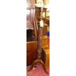 A floral carved spiral turned mahogany freestanding standard lamp, raised on hipped supports, h.
