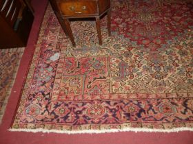 A Persian woollen red ground Heriz rug, 345 x 236cm (with several heavily worn areas to ground)