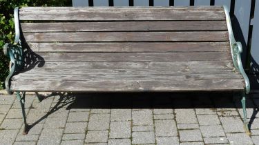 A painted pierced wrought iron ended and stained pine slatted three-seater garden bench, w.159cm