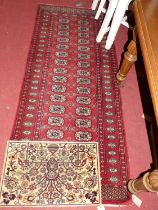 A Persian woollen red ground Bokhara hall runner, 190 x 81cm; together with a small cream ground