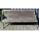 A painted pierced wrought iron ended and stained pine slatted three-seater garden bench, w.159cm