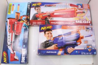 A collection of three various boxed Nerf guns to include Elite N Strike and Fortnite Nerf by Hasbro