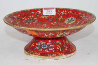 A Chinese red glazed porcelain pedestal dish, enamel decorated with chrysanthemums, bearing six