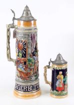 A German pottery beerstein, relief decorated with figures, h.47cm; together with another smaller (