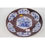 An 18th century Engish delft charger, having a central cartouche decorated with a pagoda, on a