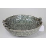 A Chinese celadon crackle glazed bowl, with moulded high relief Chi dragon decoration, dia.24cm (a/