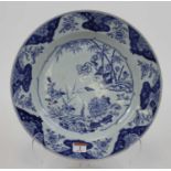 An 18th century Chinese blue and white porcelain charger, decorated with flowers, dia.35cm (a/f)