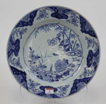 An 18th century Chinese blue and white porcelain charger, decorated with flowers, dia.35cm (a/f)