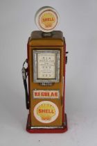 A novelty painted table-top cabinet in the form of a petrol pump, the interior fitted with