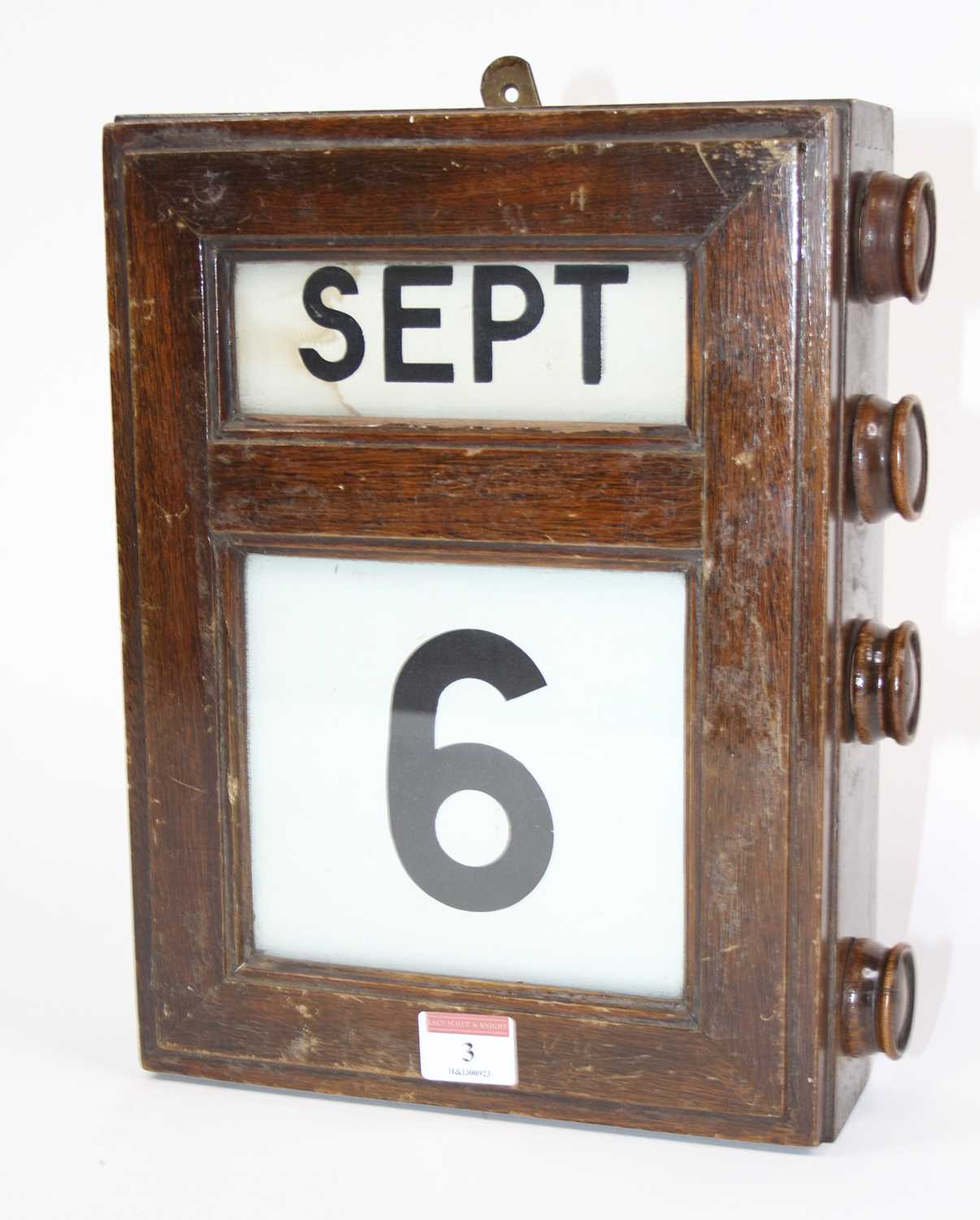 An early 20th century mahogany cased perpetual wall calendar, 30 x 24cm Linen rolls work and
