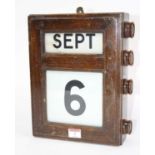 An early 20th century mahogany cased perpetual wall calendar, 30 x 24cm Linen rolls work and