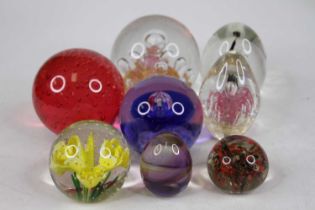 A collection of 20th century coloured glass paperweights, to include a Caithness limited edition