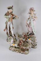 A pair of continental pottery figures of a lady and gentleman, each shown in 18th century dress on