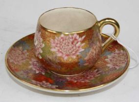 A Japanese teacup and saucer, enamel and gilt decorated with chrysanthemums, bearing a two-character