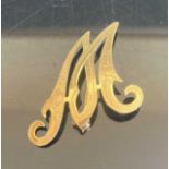A modern 18ct gold brooch formed as the letter M, with bright cut engraved decoration, 2.3g