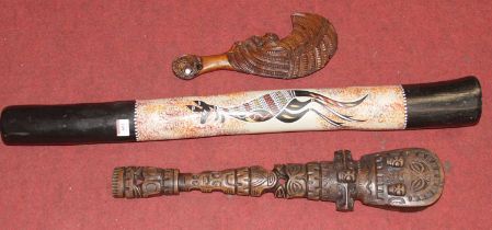 A digeridoo handpainted with a kangaroo, together with a tribal souvenir club and one other tribal