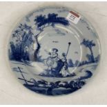 An 18th century English Delft plate underglaze blue decorated with two figures before a building