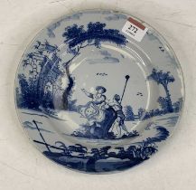 An 18th century English Delft plate underglaze blue decorated with two figures before a building