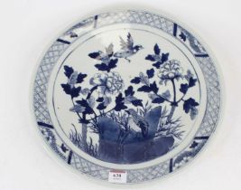 A Chinese export blue and white charger, underglaze decorated with birds amidst flowers and foliage,