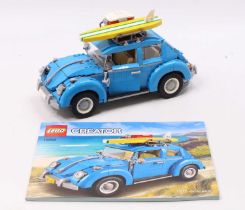 A Lego Creator built No. 10252 of a Volkswagen Beetle with surfboard and coolbox load