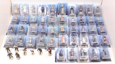 A collection of various boxed and loose Assasins Creed by Hachette action figures, all housed on