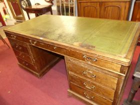 A 20th century faded mahogany round cornered twin pedestal writing desk, having gilt-tooled green