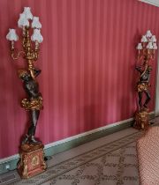 A large pair of contemporary Blackamoor figural floor lamps, each issuing six scroll branches, in