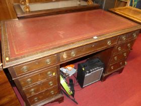 A mahogany twin pedestal writing desk, having a gilt tooled red hide inset surface, over an