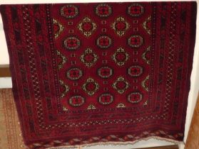 A Persian woollen red ground Bokhara rug, having multiple trailing tramline borders, 190 x 135cm