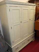 A contemporary painted pine three door wardrobe, having twin lower drawers, w.173cm