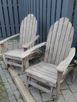 A pair of contemporary stained and slatted pine garden open armchairs, each with pull-out foot