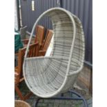 A contemporary painted tubular metal and rattan swinging garden bucket seat