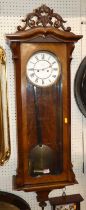 A circa 1900 figured walnut Vienna regulator dropfront wall clock, with white enamel dial,