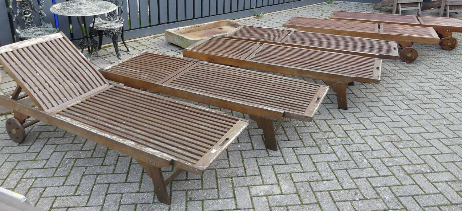 A set of six contemporary stained and slatted teak sun loungers, having adjustable ratchet