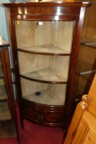 A circa 1900 mahogany freestanding bowfront corner display cabinet, having a glazed door and lined