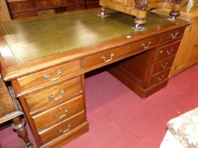 A 20th century mahogany and gilt tooled green leather inset twin pedestal writing desk, having an