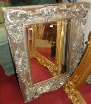 A contemporary silvered floral decorated bevelled rectangular wall mirror, 82 x 108cm