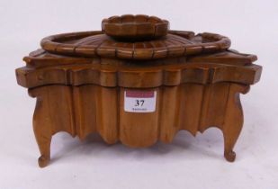 A continental walnut table top box of shaped outline, the hinged lid surmounted by a flower and