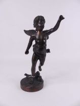 A bronzed figure of a cherub, modelled standing on a naturalistic circular base, height 33cm