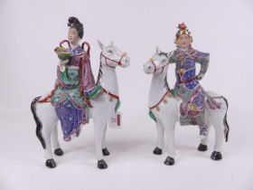 A pair of Chinese porcelain figures of a lady and gentleman each clothed in ceremonial dress, seated