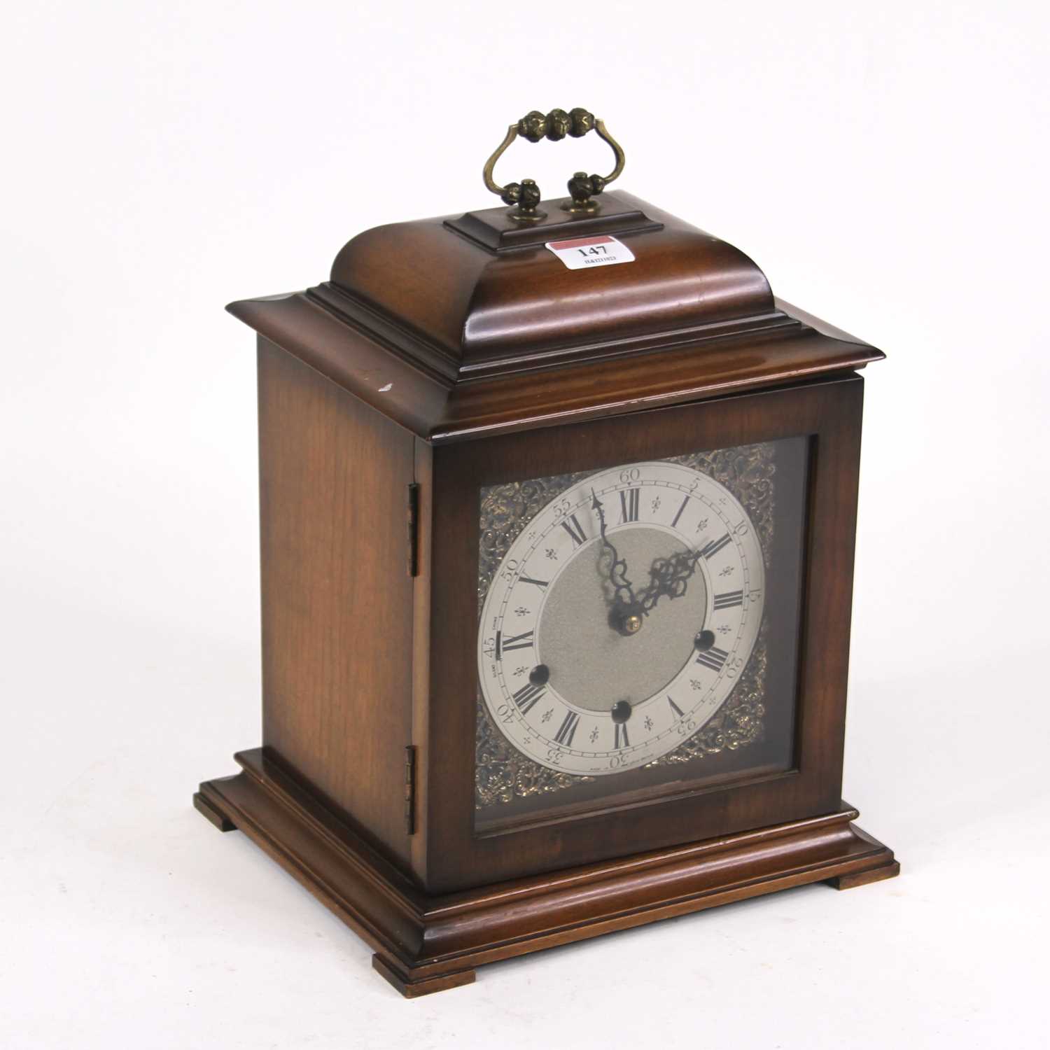 A walnut cased bracket clock in the 18th century style having a silvered chapter ring with Roman