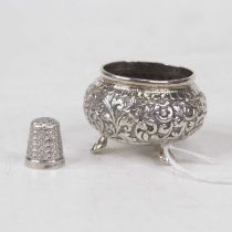 An Eastern white metal salt, of squat oval form with repousse decoration, on cast paw feet; together